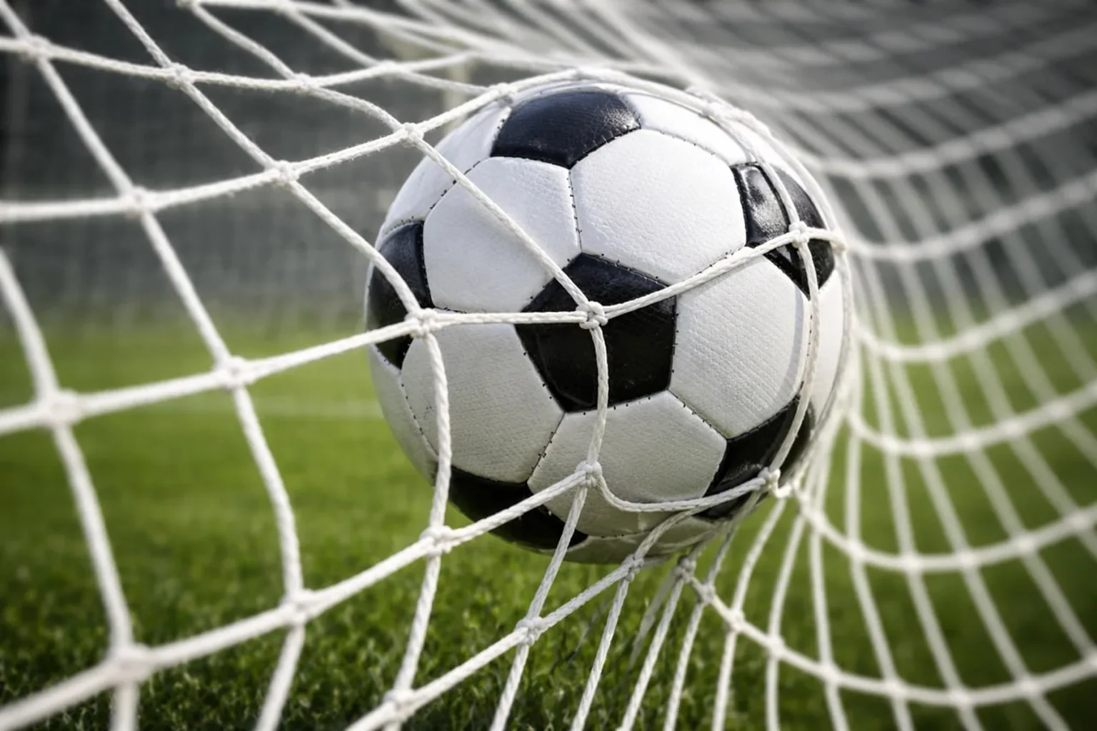 Pallone da calcio che entra nella rete della porta