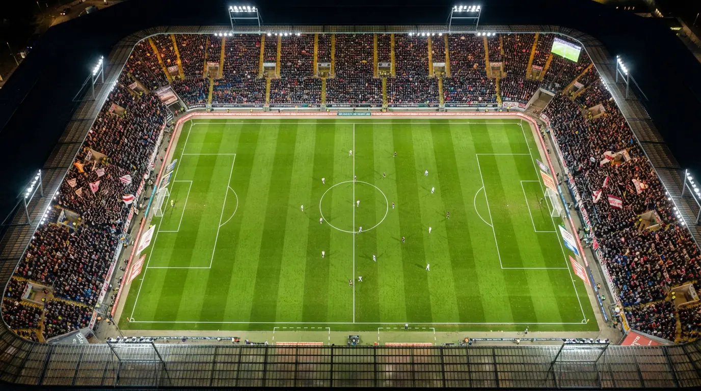Vista aerea di un campo da calcio tedesco con le linee del campo illuminate durante una partita notturna